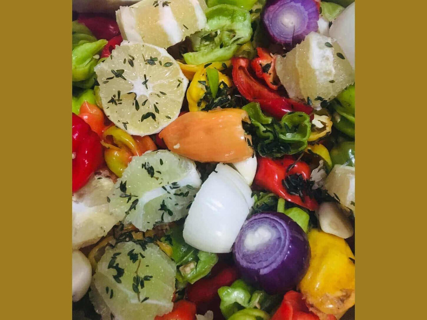 Fresh mixed peppers, onions, and sliced lime with herbs for artisan hot sauce preparation