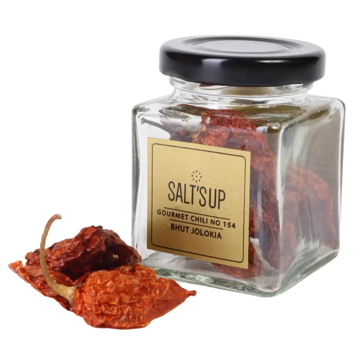 Glass jar of gourmet Bhut Jolokia dried chili peppers with two chilies in front