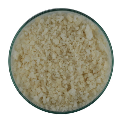 Coarse natural sea salt crystals in a glass bowl on white background