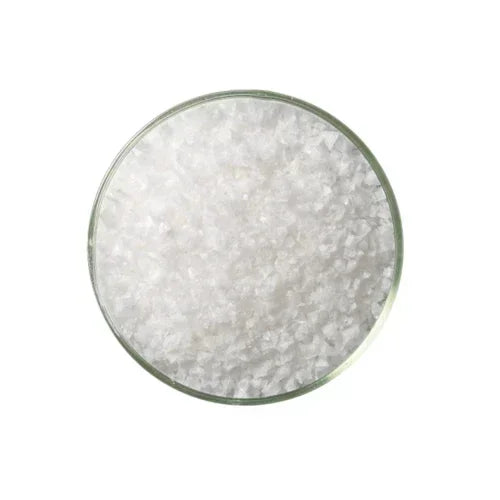 Close-up of white crystal salt flakes in a clear glass bowl, gourmet seasoning