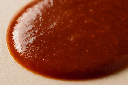 Macro shot of rich brown sauce texture on a neutral surface