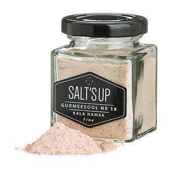 Glass jar of Kala Namak fine gourmet salt with loose pink salt pile, labeled Salt's Up.