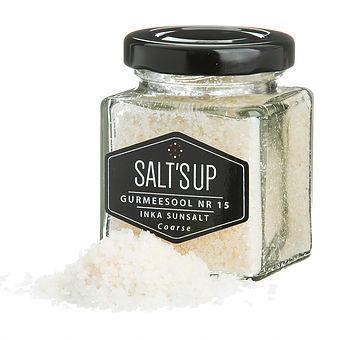Glass jar of Salt's Up coarse Inka sun salt with spilled crystals, gourmet seasoning product