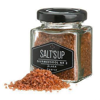 Jar of Salt's Up Alaea coarse red sea salt with granules spilled, gourmet spice market product.