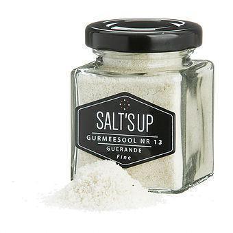 Square glass jar of Salt's Up fine Guerande sea salt with some salt spilled in front, gourmet seasoning