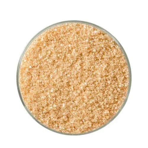 Glass bowl filled with coarse golden-brown smoked sugar crystals, top view