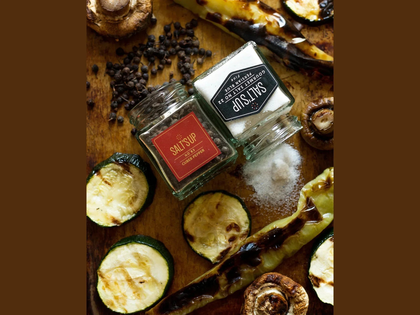 Cubeb pepper and salt jars with grilled zucchini, mushrooms, and whole peppercorns