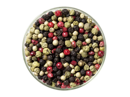 Mixed Kampot peppercorns in glass bowl, featuring red, green, black and white pepper.