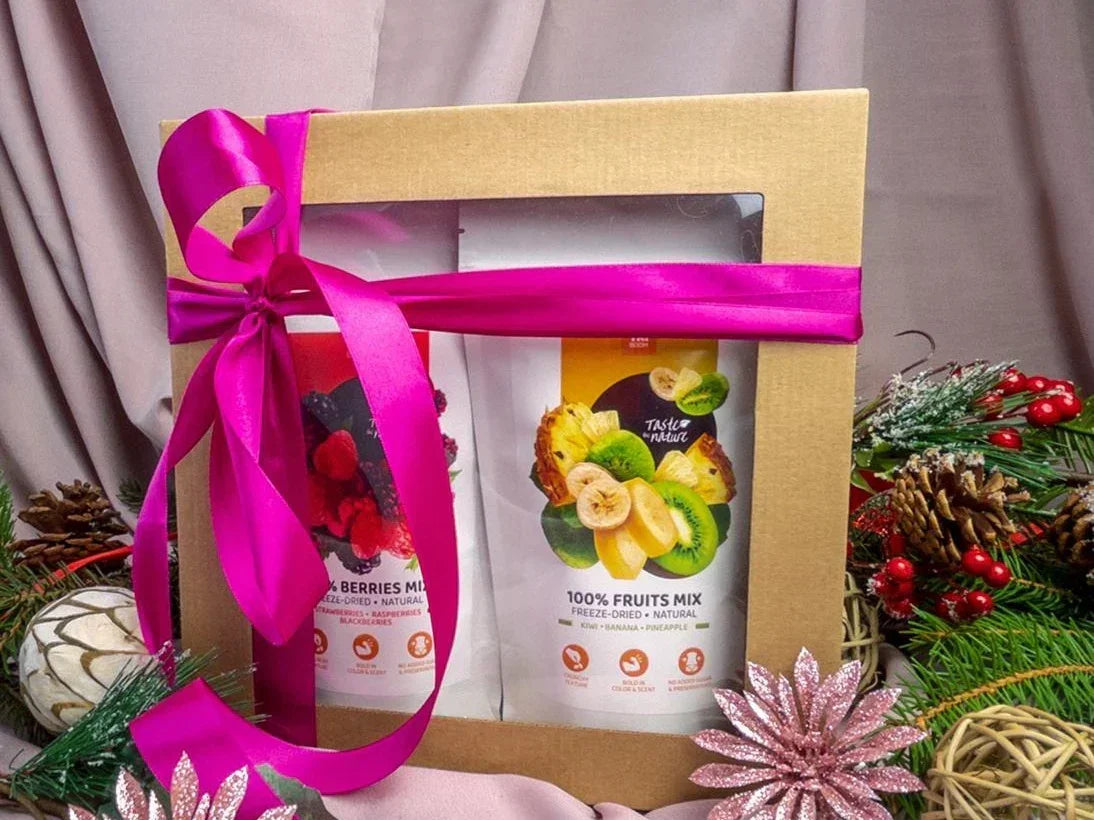 Gift box with freeze-dried mixed berries and fruit snacks, pink ribbon, festive decor
