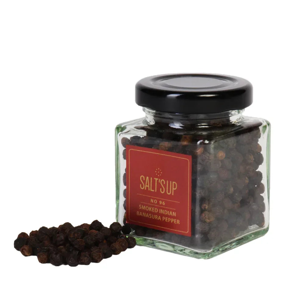 Glass jar of Salt's Up Smoked Indian Banasura peppercorns with loose peppercorns, Spice n Slice Market.