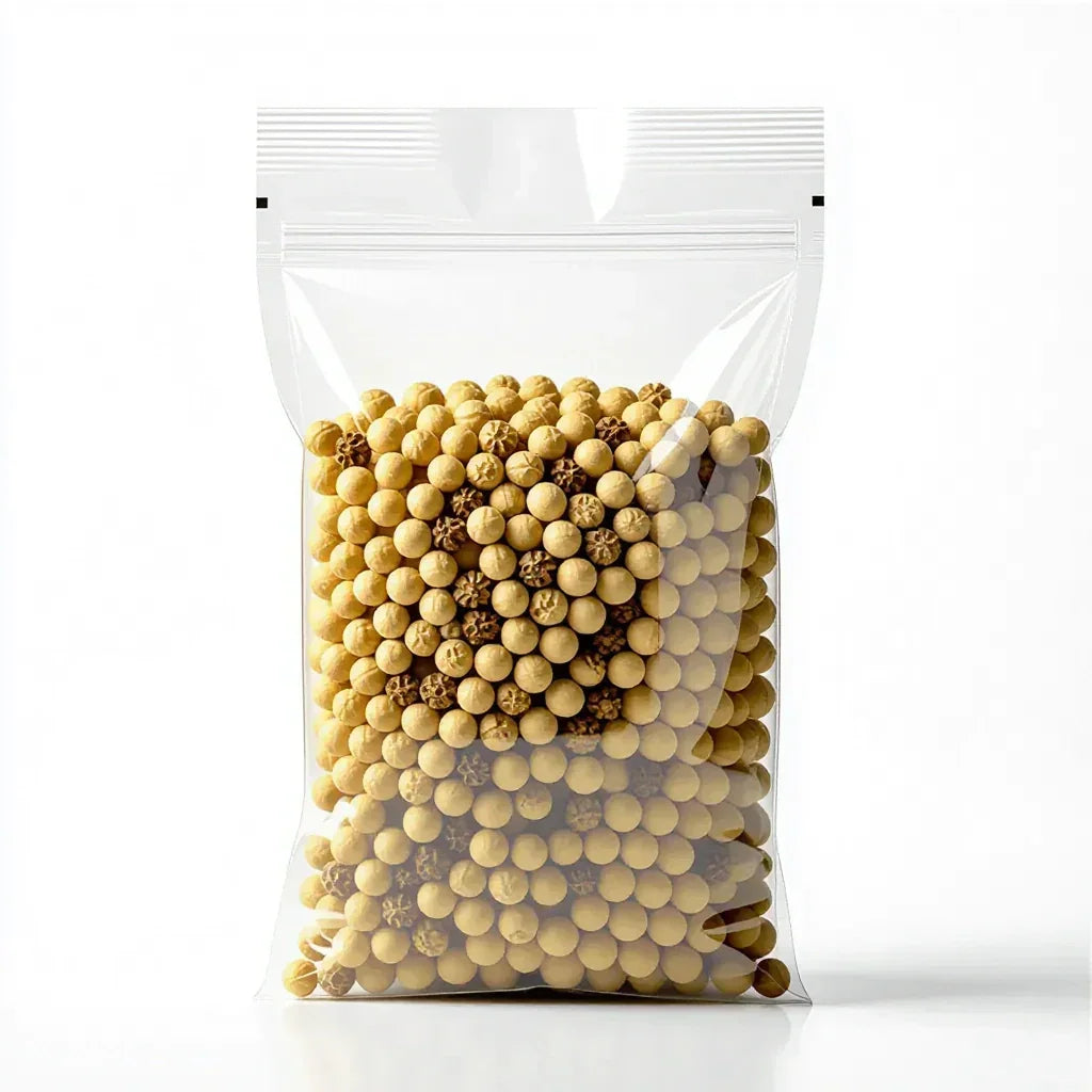 Clear resealable bag filled with small yellow and brown round beads on white background