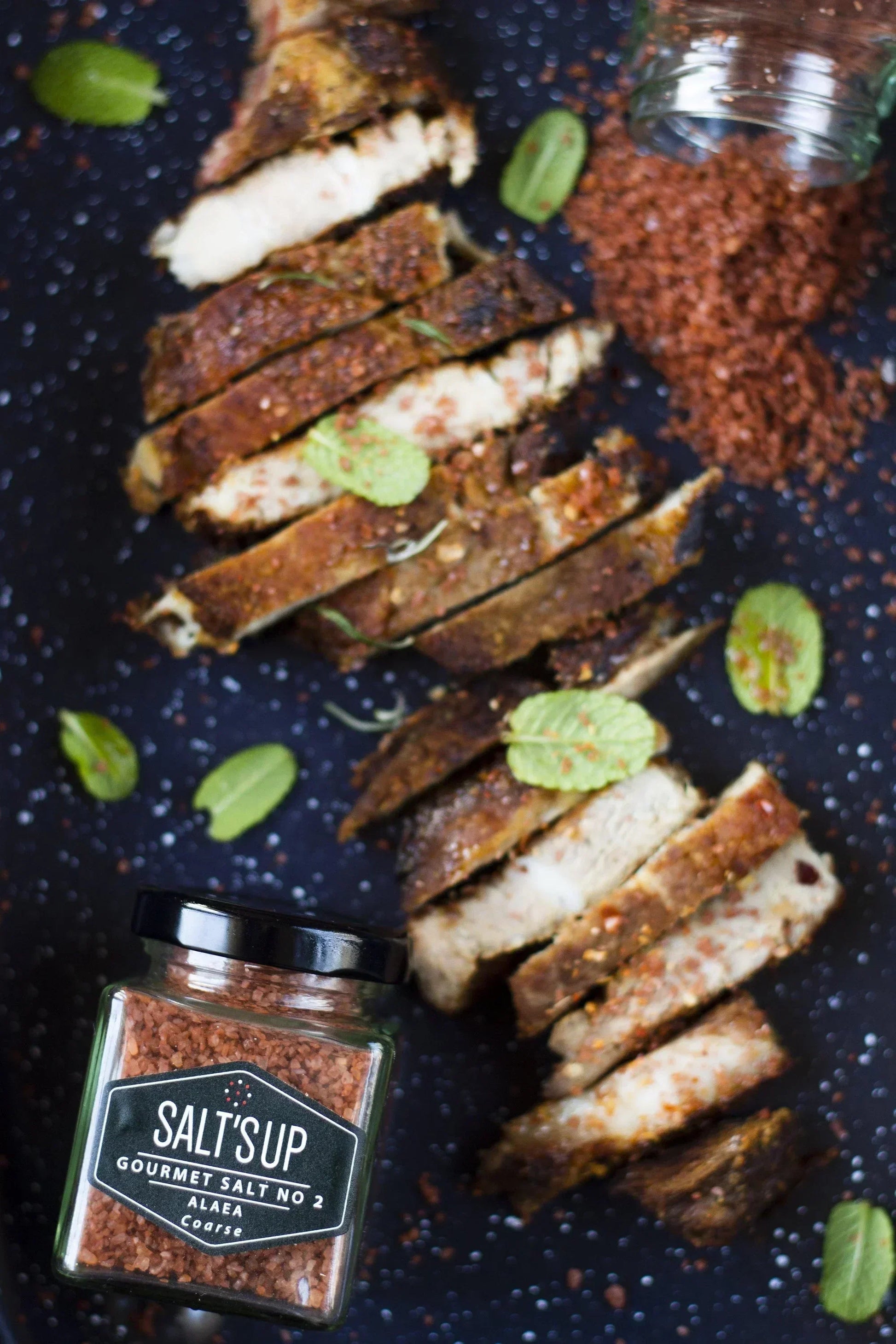 Sliced grilled meat seasoned with Salt's Up Alaea coarse gourmet salt, fresh herbs, and spice blend