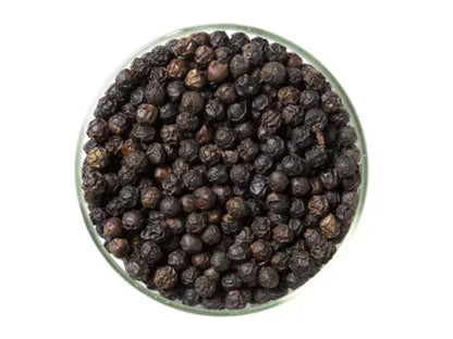 Glass bowl filled with whole black peppercorns on a white background