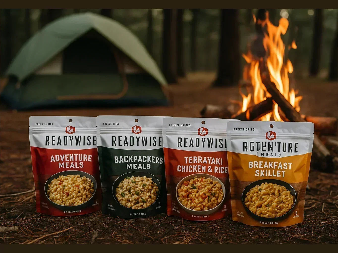Freeze-dried camping meals, including Adventure and Backpacker options, in front of a tent and campfire