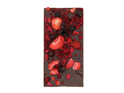 Dark chocolate bar topped with dried strawberries and blueberries on black background