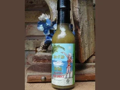 Green chili habanero hot sauce bottle with tropical label on rustic background