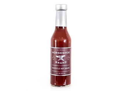Glass bottle of chipotle hot sauce with silver cap and clear label on white background