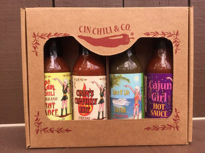 Box set of four artisan hot sauces in colorful bottles with illustrated labels
