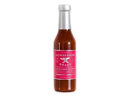 Glass bottle of Horseshoe Brand Korean ginger hot sauce with pink label on white background
