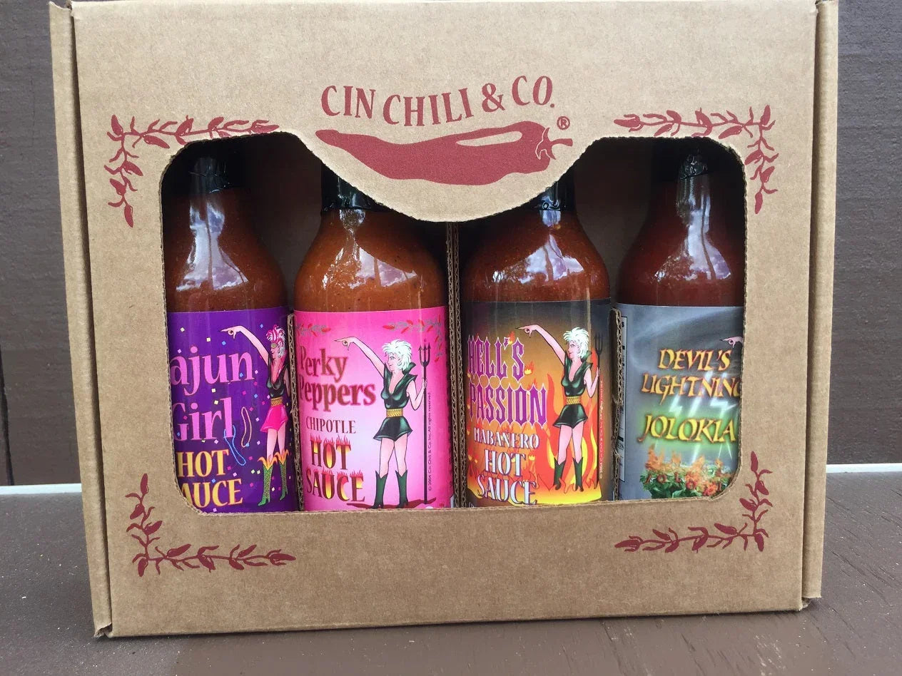 Gift set of four artisan hot sauce bottles in decorative box with colorful labels
