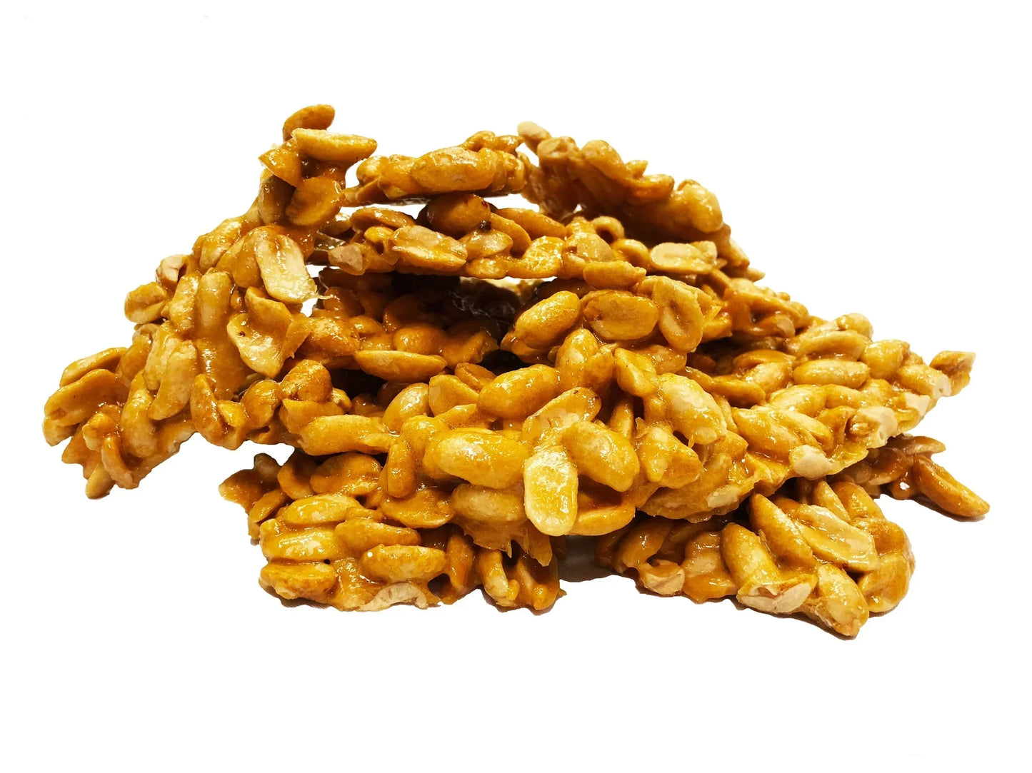 Peanut brittle clusters with caramelized sugar, close-up on white background