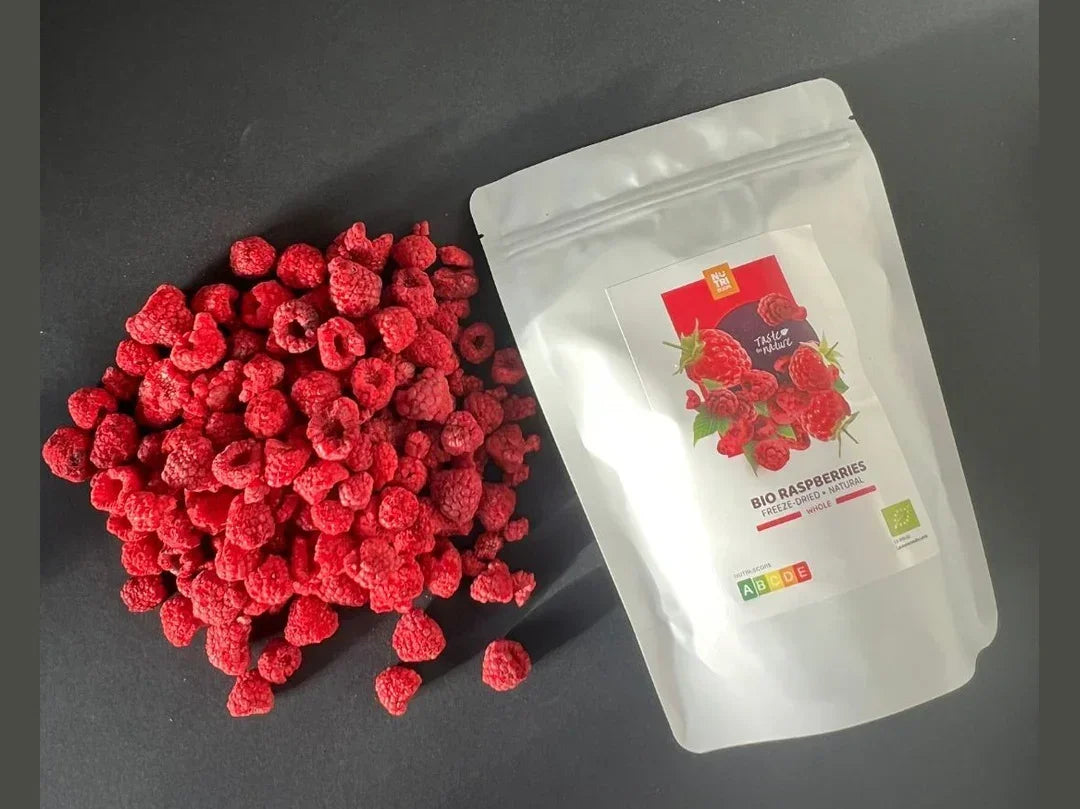 Freeze-dried organic raspberries with resealable pouch on a dark background, healthy snack