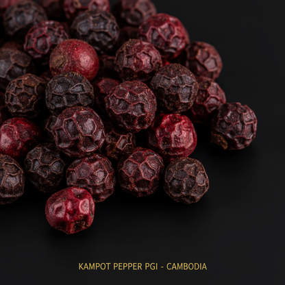 Dark red Kampot pepper PGI macro close up deep burgundy peppercorns on black background