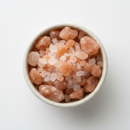 Close-up of Himalayan pink salt crystals in a small ceramic bowl showing texture and color
