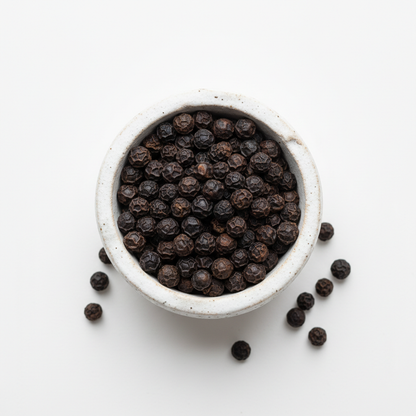 Kampot black pepper PGI peppercorns in ceramic bowl overhead shot