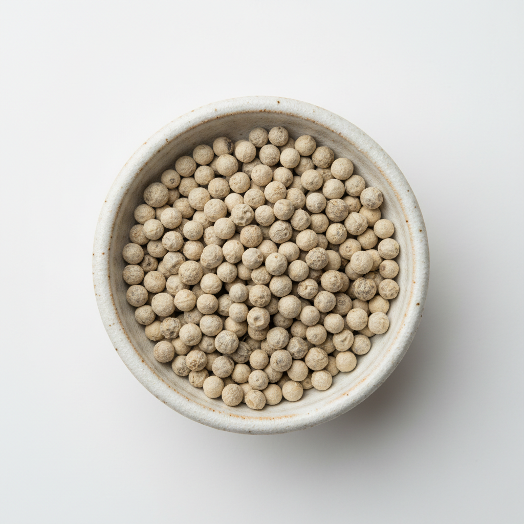 Kampot white pepper PGI peppercorns in ceramic bowl overhead shot