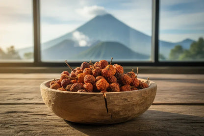 Wooden bowl of dried chili peppers on a rustic table with a mountain view in the background