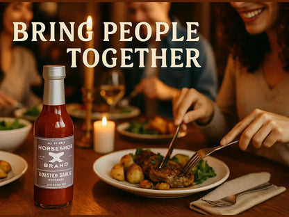 Roasted garlic hot sauce bottle on dinner table with people enjoying a meal and candlelight