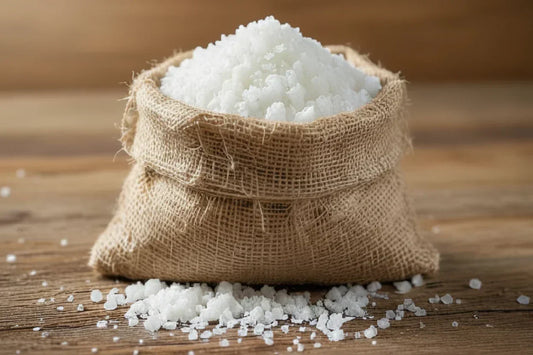 Coarse sea salt in burlap sack on rustic wooden table