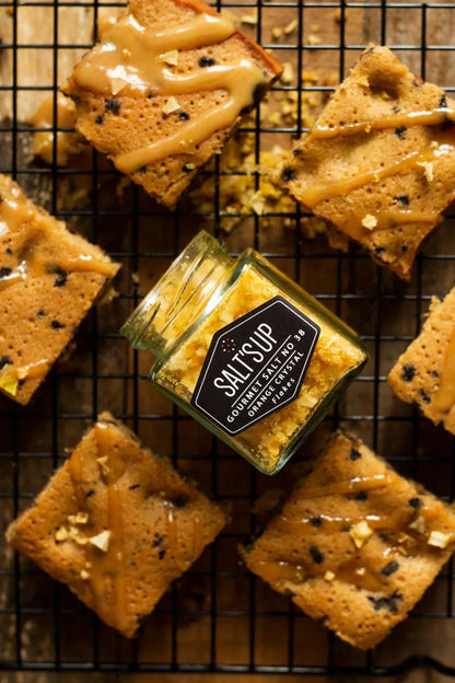 Gourmet orange crystal salt jar on cooling rack with caramel-drizzled blondies, Spice n Slice Market