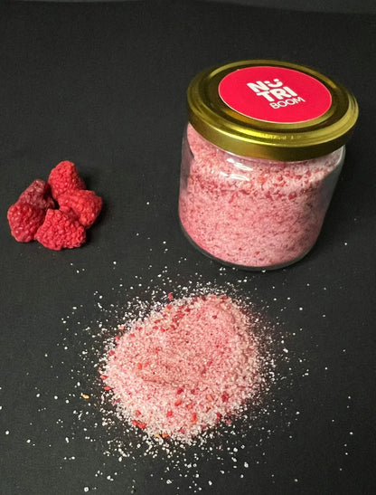 Jar of raspberry sugar with freeze-dried raspberries and pink sugar on black background