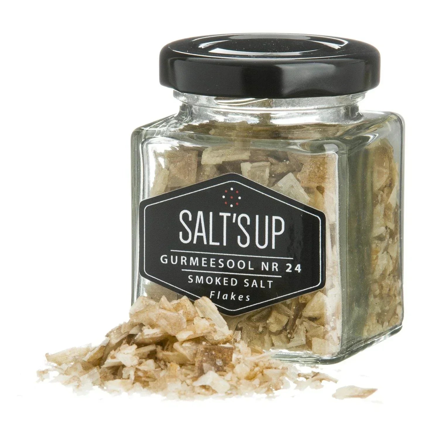 Glass jar of smoked salt flakes with label and salt flakes spilled in front